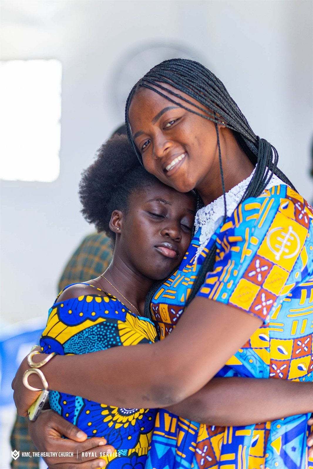 Two members of KMC embracing during a service