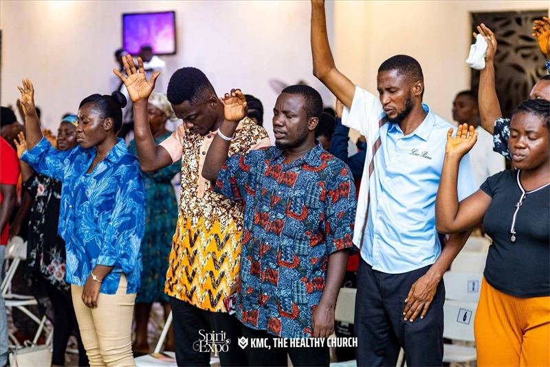 Congregation in worship with hands raised